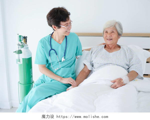 护士在病床前照顾老年妇女微笑的护士医护人员